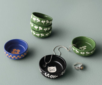Set of small ceramic dishes with decorative patterns on a gray background