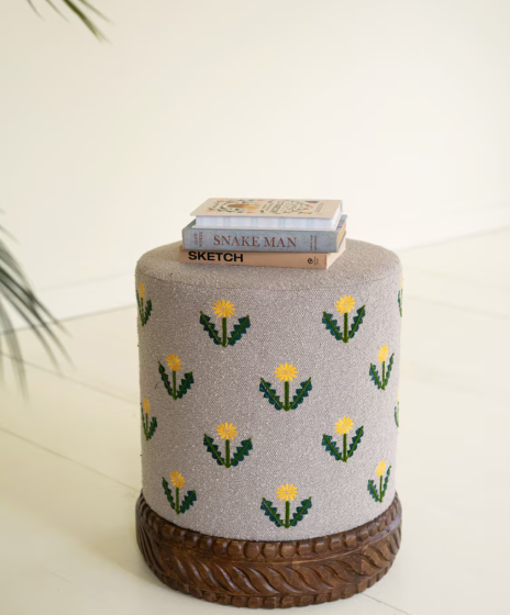 Grey Upholstered Ottoman with Embroidered Detail and Carved Wood Base